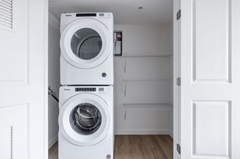 Two white front loading washing machines in a laundry room.